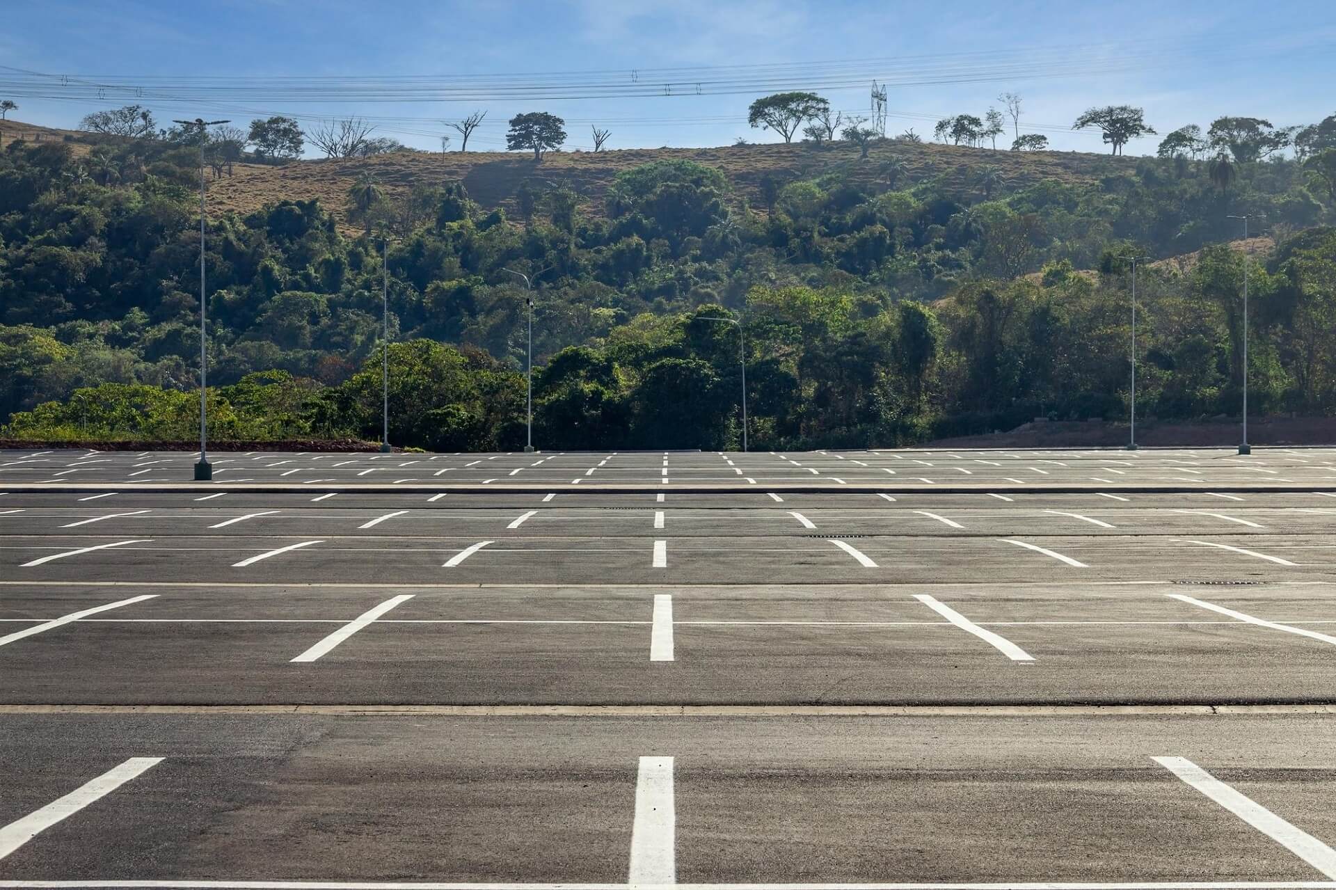 big-parking-lot-completely-empty-with-hill-covered-by-vegetation-background (2) (1) Avada Car Dealership